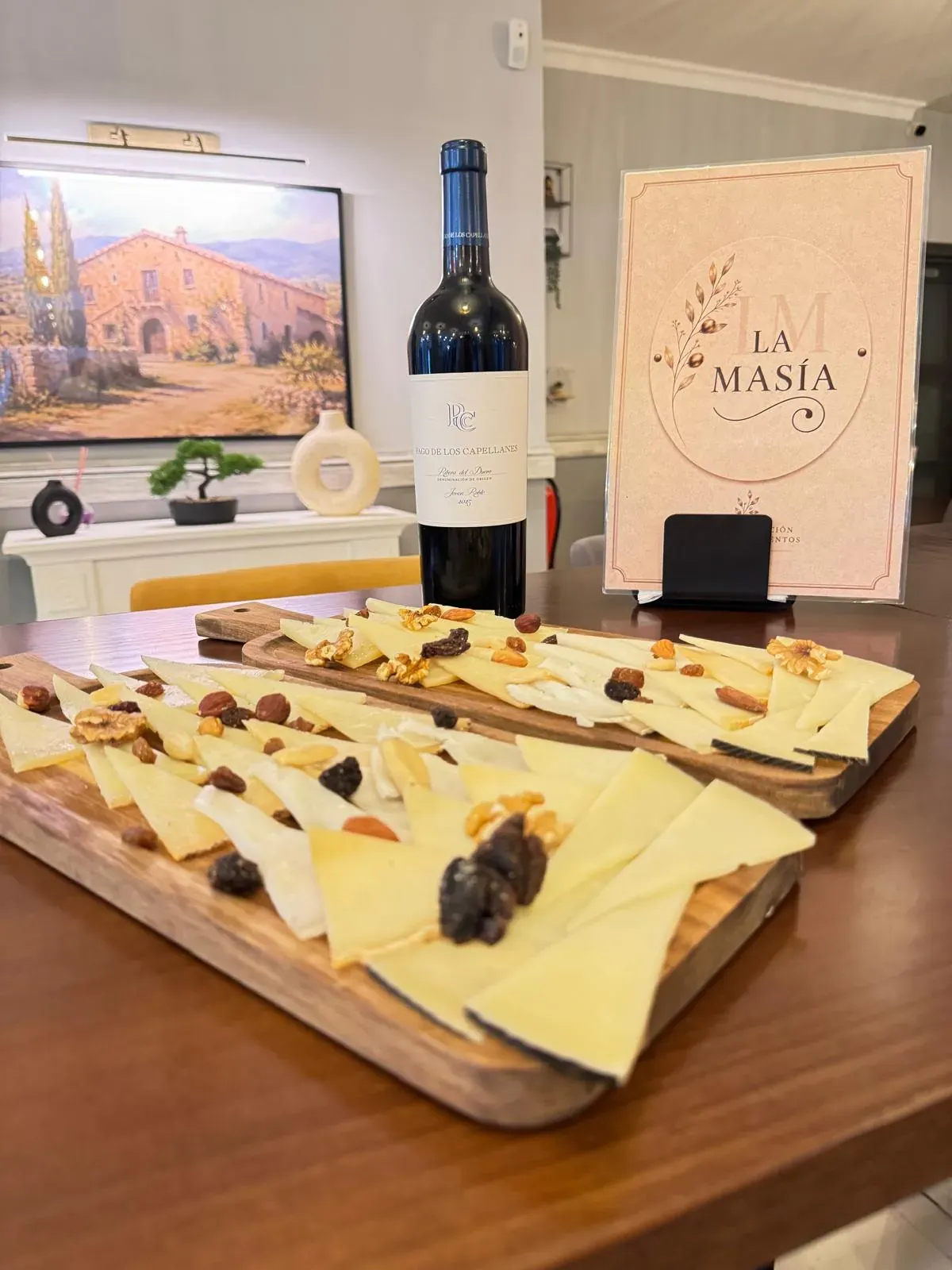 Tabla de quesos con frutos secos y la carta de La Masía